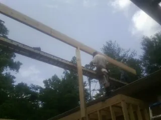 Carpenter setting a ridge beam over a new addition frame — Ice Dam Removal by Roofing Brothers in White Mills