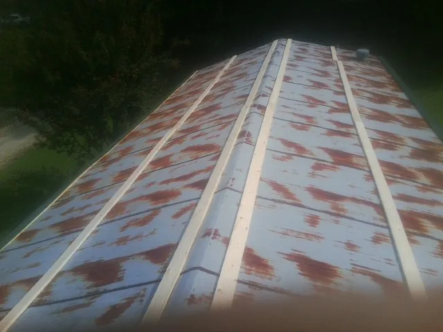 Rusted metal roof panels with new wood purlins before replacement — Storm Damage Roof Repair in White Mills by Roofing Brothers