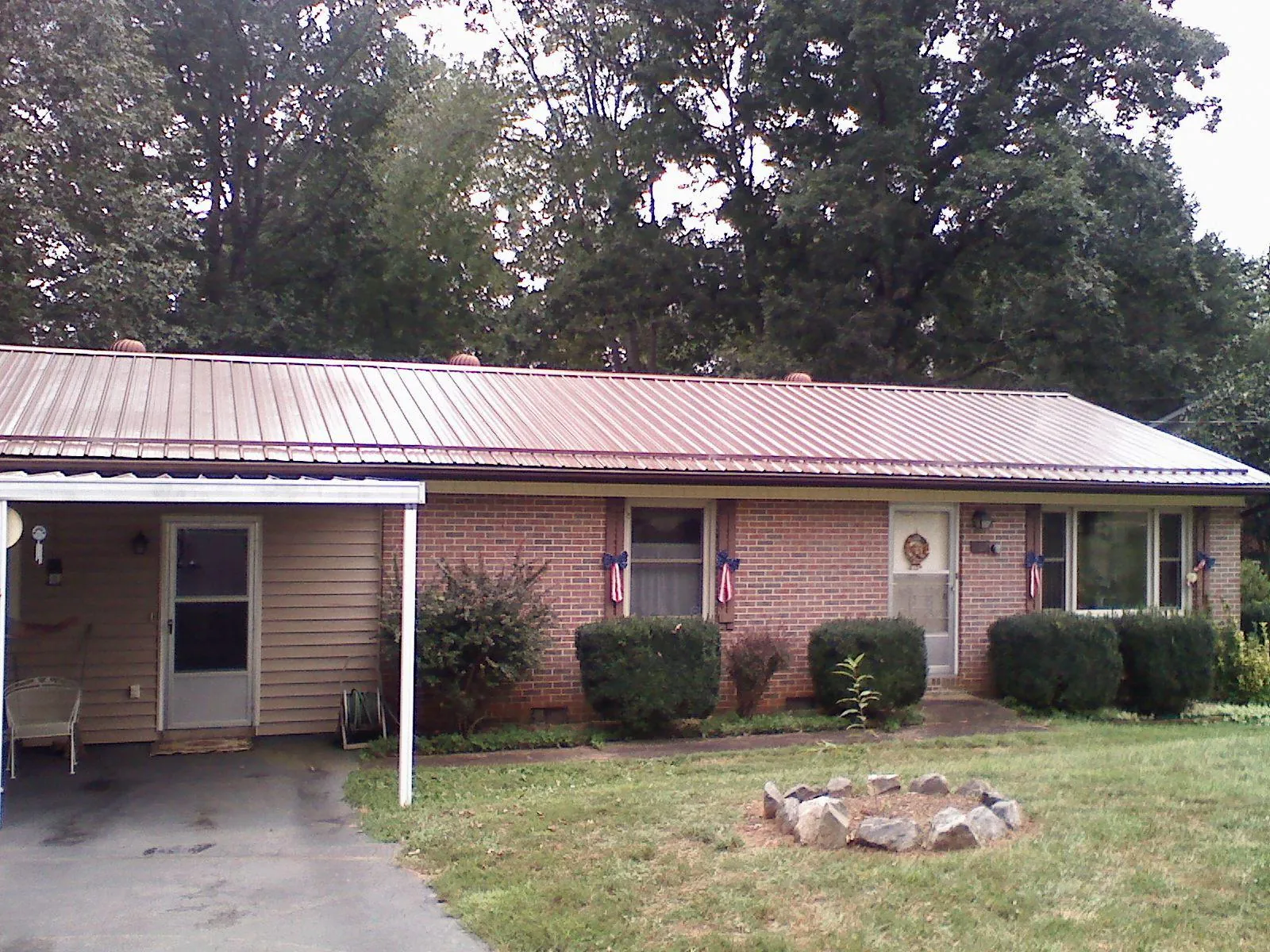 Bronze metal roof and carport on a brick ranch home — Roof Repair work by our crew in White Mills
